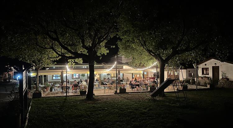 In the dark a well lit semi outdoor area with people dining