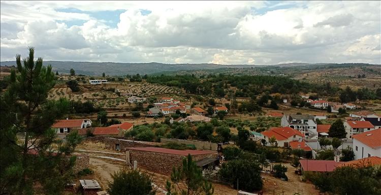 Looking out over portuguese terracotta rooftops to dry farmland and hills