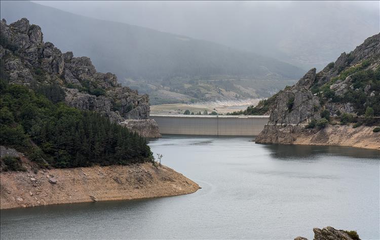 The waters in the valley lead to a concrete dam