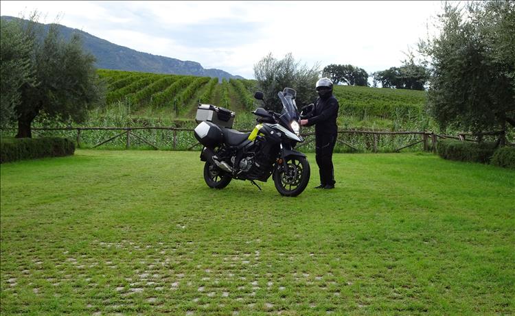 Mrs Upt' all in black bike gear is by the Vstrom 650 with green hills behind