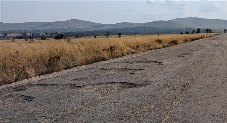 An dull orange road with potholes