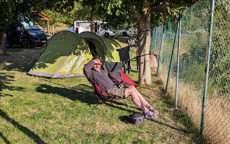 Ren by the tent sat in a chair shielding his eyes from the low evening sun