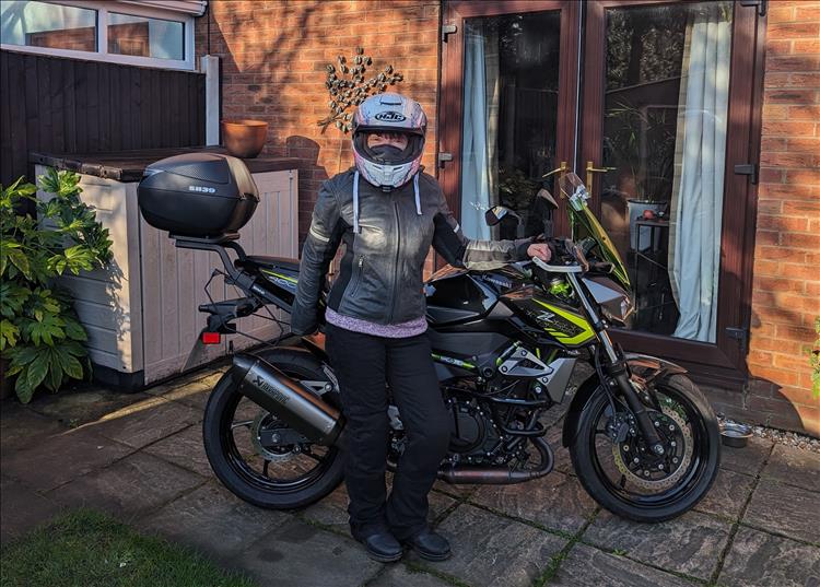 Sharon in her bike kit stands proudly before the Z400 in her own garden