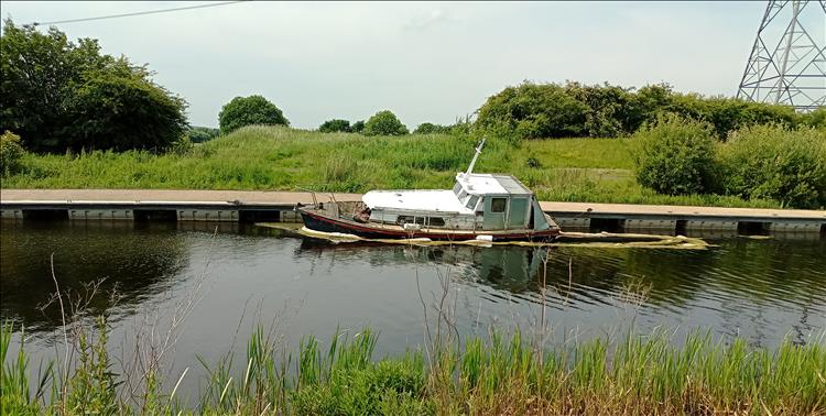 A sunken boat along the canal near the kelpies