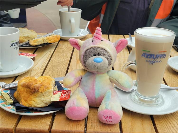 The stuffed cute unicorn on the cafe table among scones and cups at Wemyss Bay