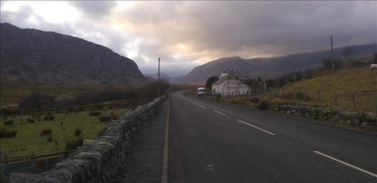 The welsh mountains with ominous clouds, the road is damp but it's not raining