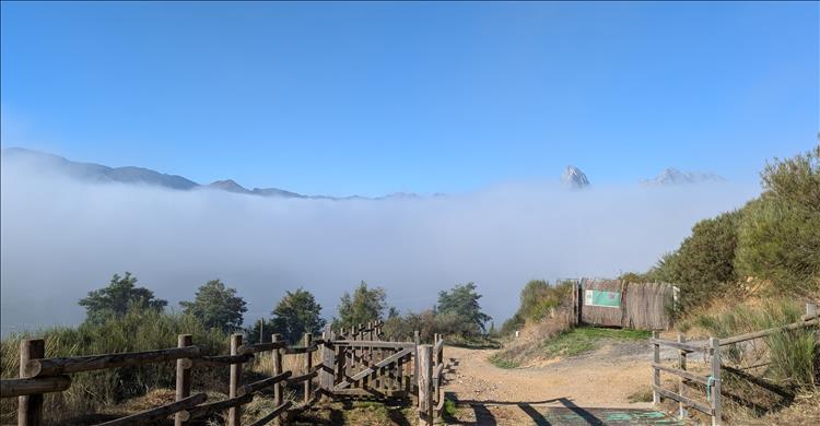 A dense layer of mist with just the peaks of the surrounding mountain poking out