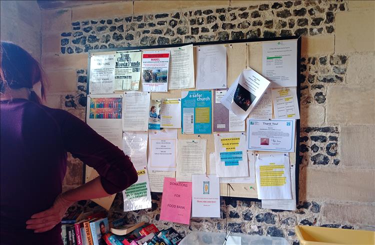 A typical small village notice board within the porch of the church, filled with various pinned notices