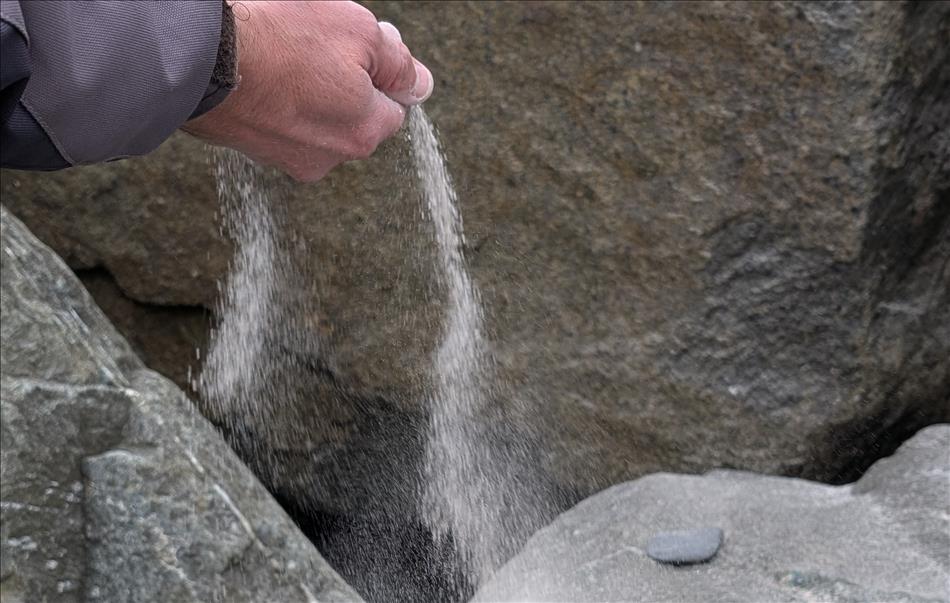 A hand with some ash being released from the fingers