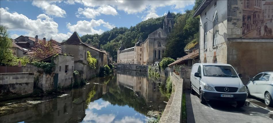 A river is calm set down in stone walls, french buildings and a boulevard