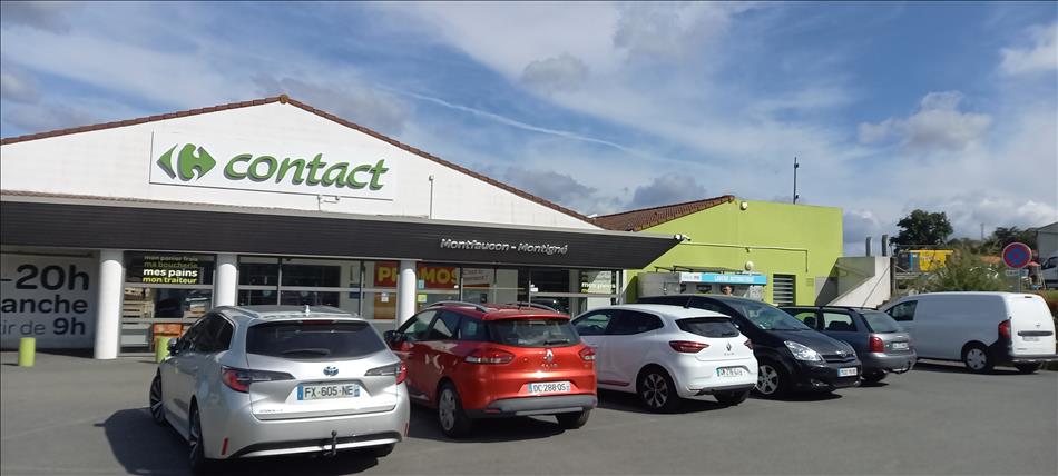 A local supermarket in france, the sun is out and cars in the car park
