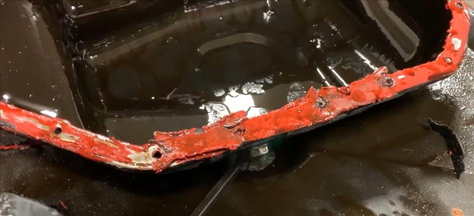 An engine sump with the mating surface lathered in a thick layer of bright orange RTV