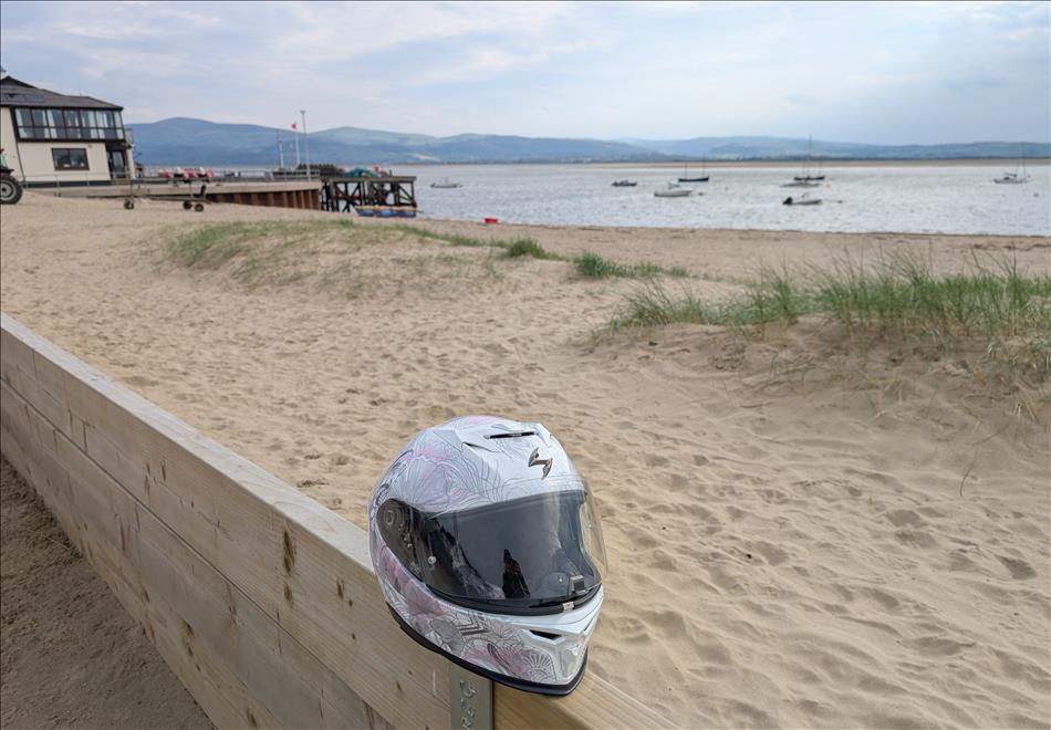 A helmet on a wooden wall with the beach, harbour and sea behind
