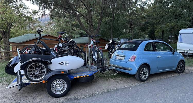 The small fialt 500 and the large loaded trailer from the other side