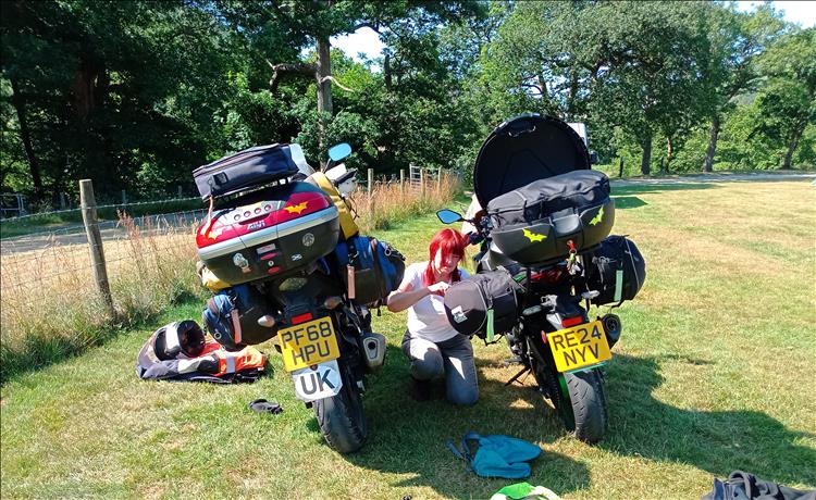 Sharon is between the 2 motorcycles as all the camping gear luggage is being loaded