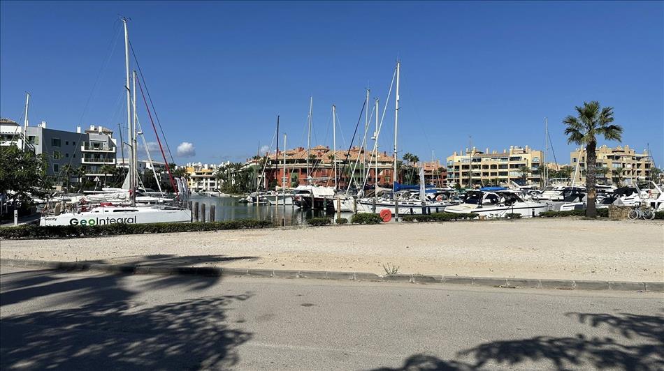 A marina with small sailing boats. The typical 3-4 storey apartment blocks behind