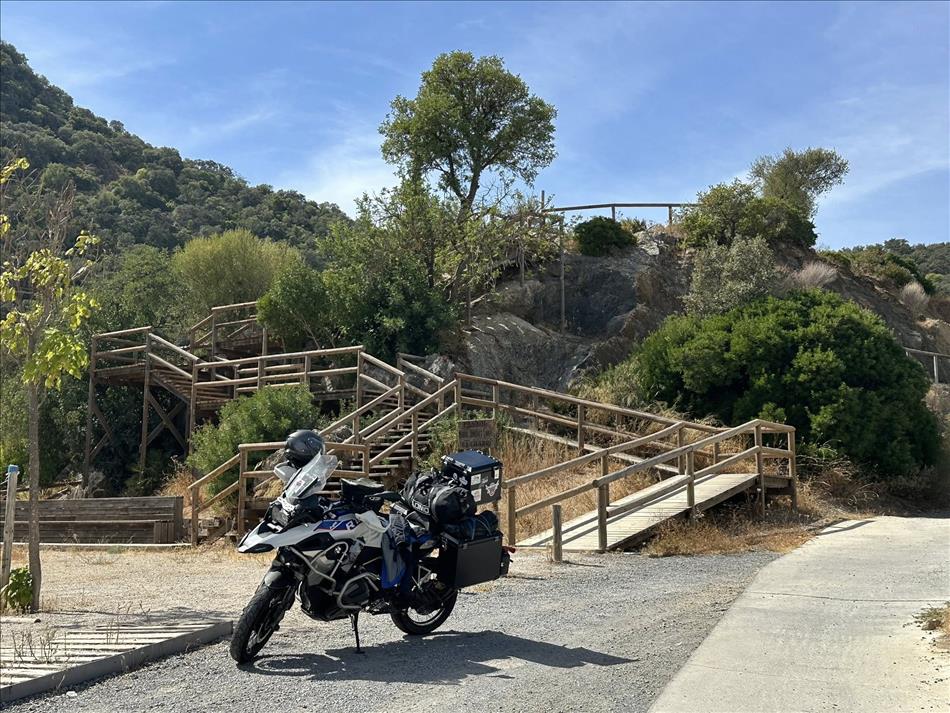 Wooden framed steps zi-zag a short ways up a hillside, Andy's bike parked in the space in front