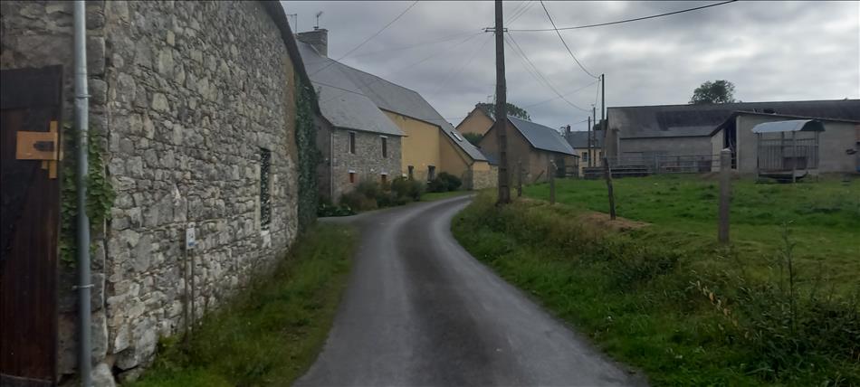 Old stone buildings along a narrow lane, typically French