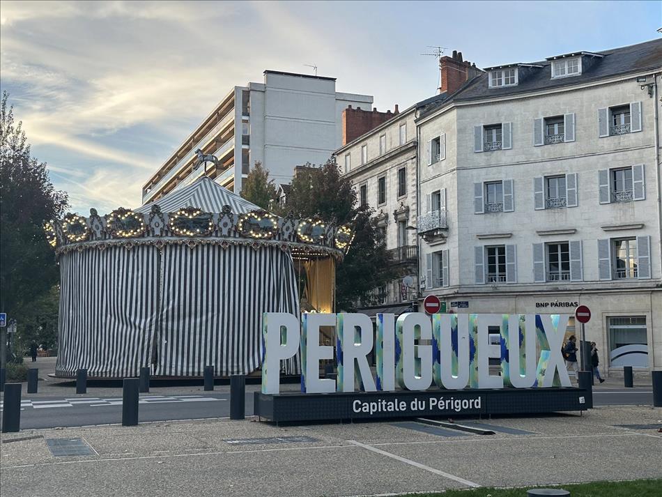 A large modern set of 3d letters spells PERIGEUEX and the modern town behind