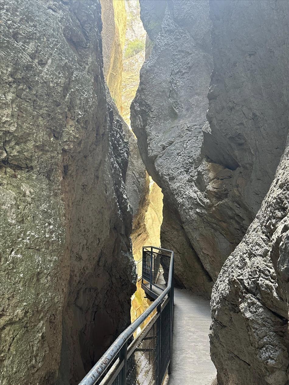 Deep in the gap of the gorge sunlight illuminates some of the rocks giving them a golden hue
