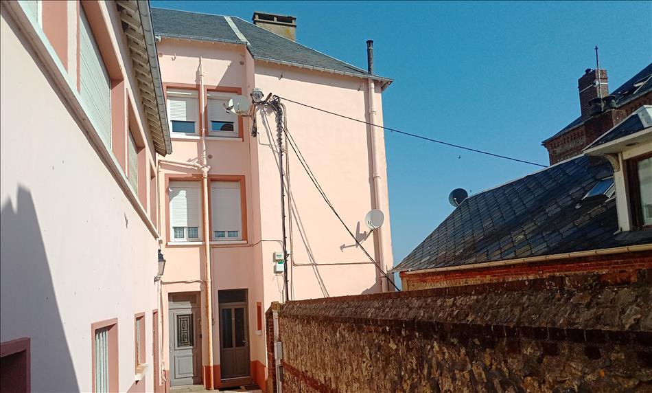 The back of a building, plain with doors, satellite dish and lots of cables