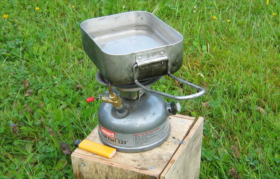 THe coleman 533 dual fuel stove with a cooking tin atop