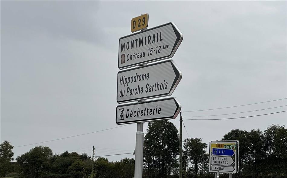 Several direction signs, the bottom one reads Dechetterie