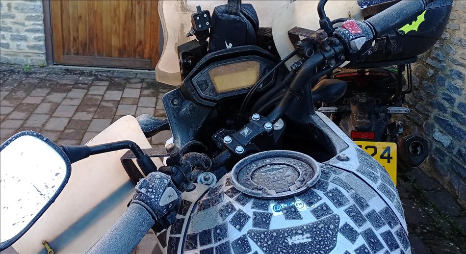 The tank and clocks on Ren's bike are covered in frost and hard frozen rain drops