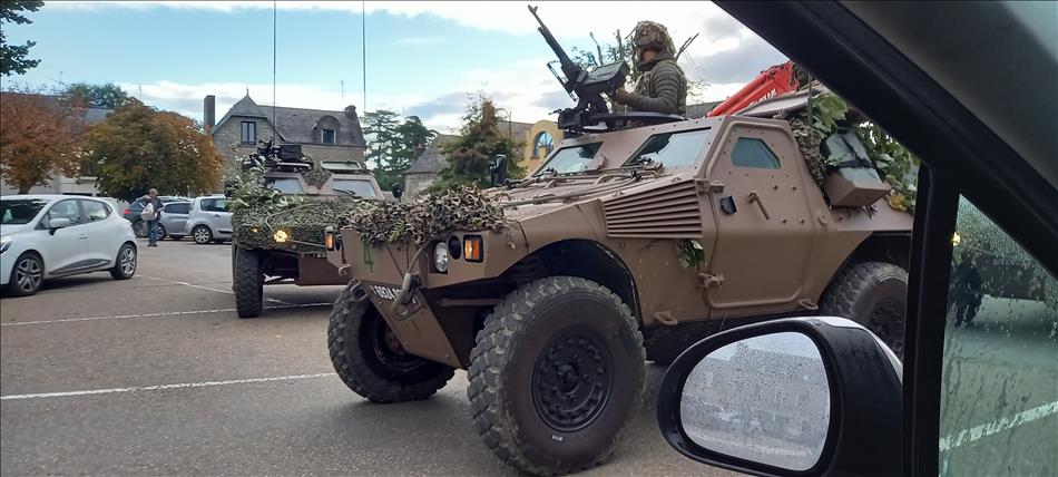 2 modern armoured cars complete with guns and troops in the pretty town