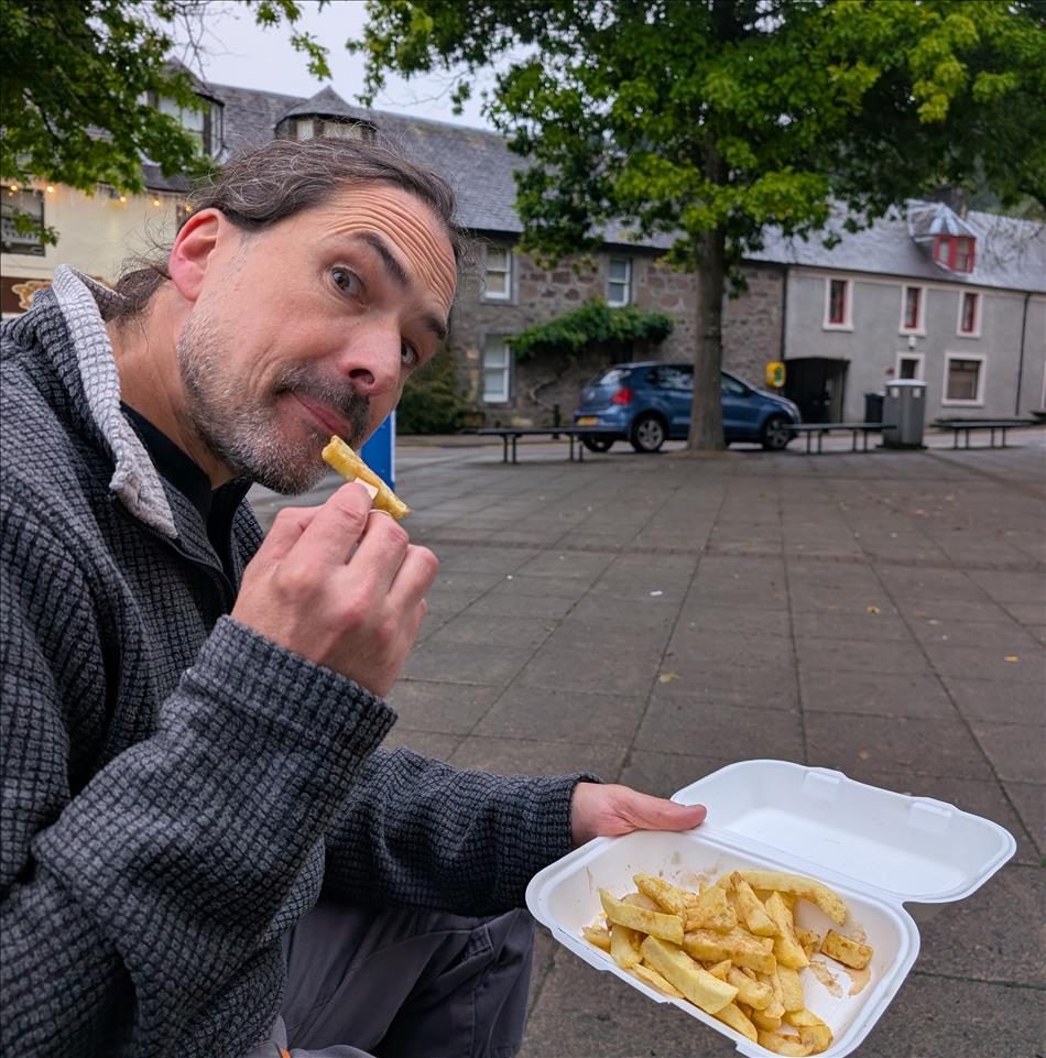 Ren has a cheeky face as he's about to eat a chip from the tray