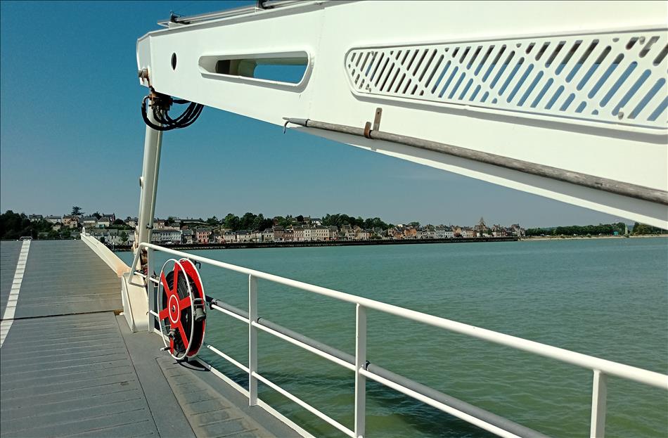 From a small ferry deck we see the landing ramp, the river Seine and a few properties on the river bank