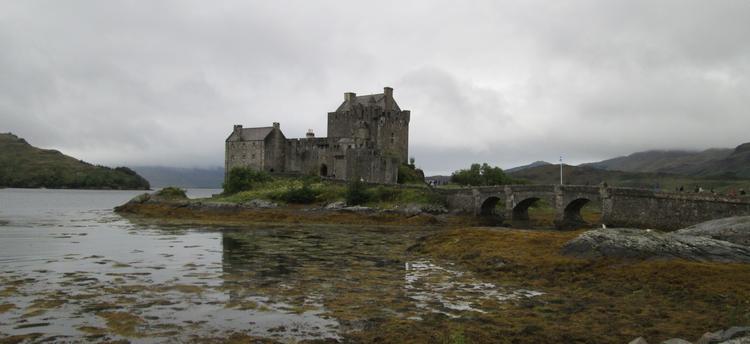 The Eilean Donan Castle against a dark sky and the murky loch