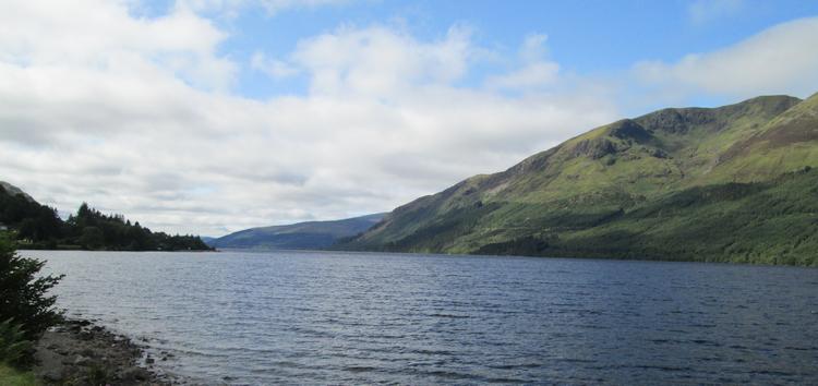 Loch Lochy in the sun. Big hills, whispy clouds and blue waters