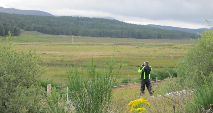 Mark stands overlooking trees and empty moorlands not far from Lochcarron