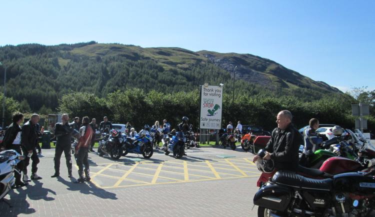 A collection of bikers enjoy the sun on the car park outside the Green Welly Tyndrum