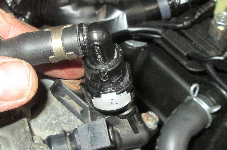 A black connector with a white insert on the high pressure fuel line to the injectors