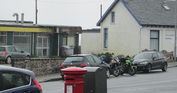 The rain lashes the cars and motorcycles and properties in Dunoon